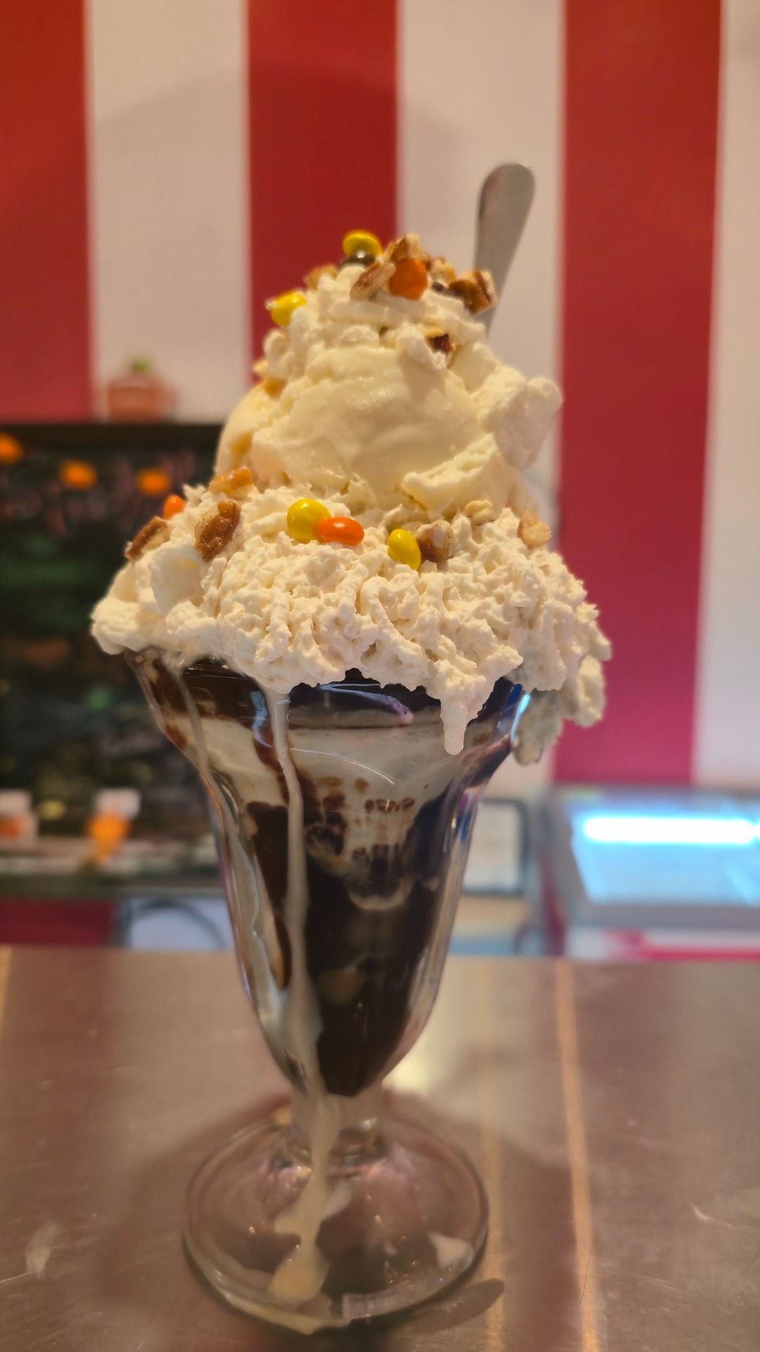Towering loaded sundae in a classic glass with whipped cream and candy toppings